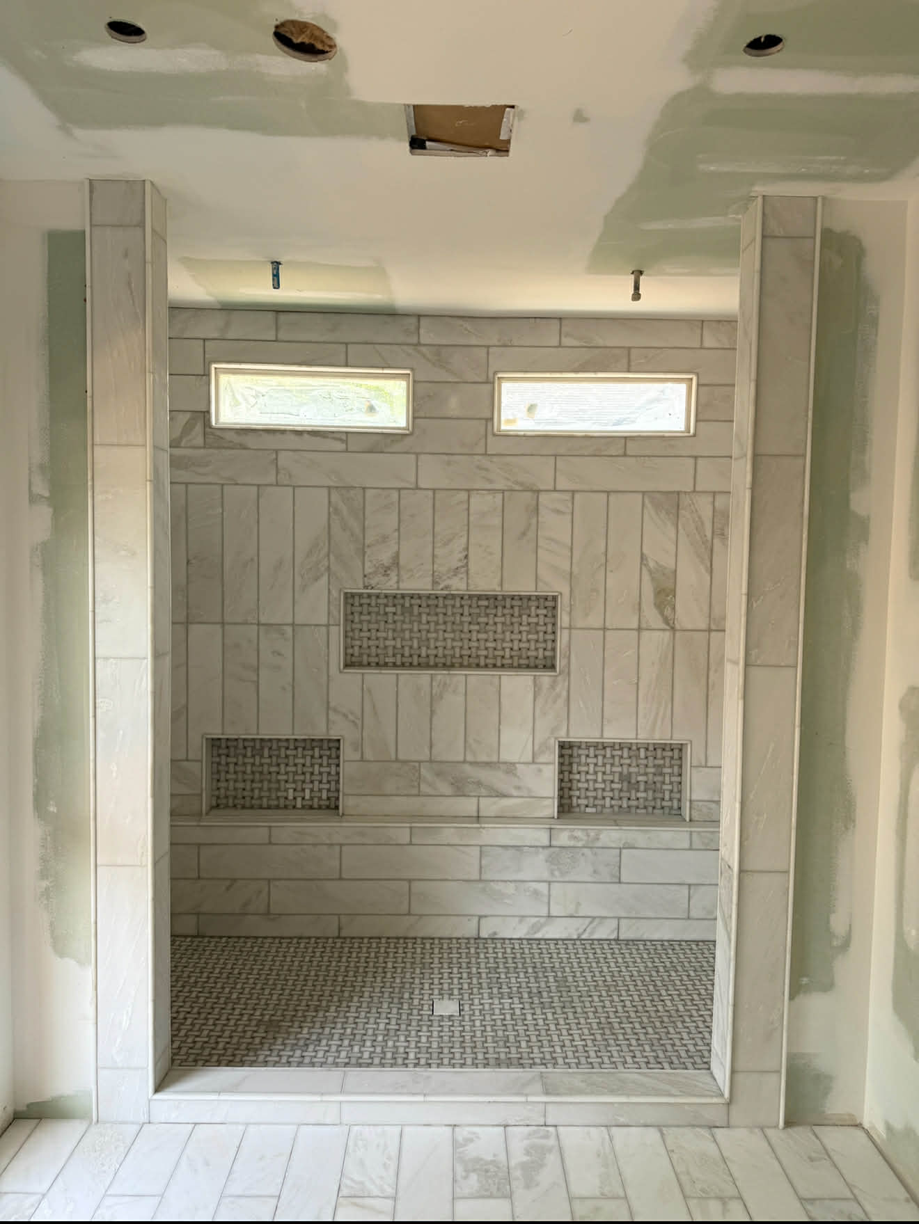 Walk-in marble shower with bench and niches