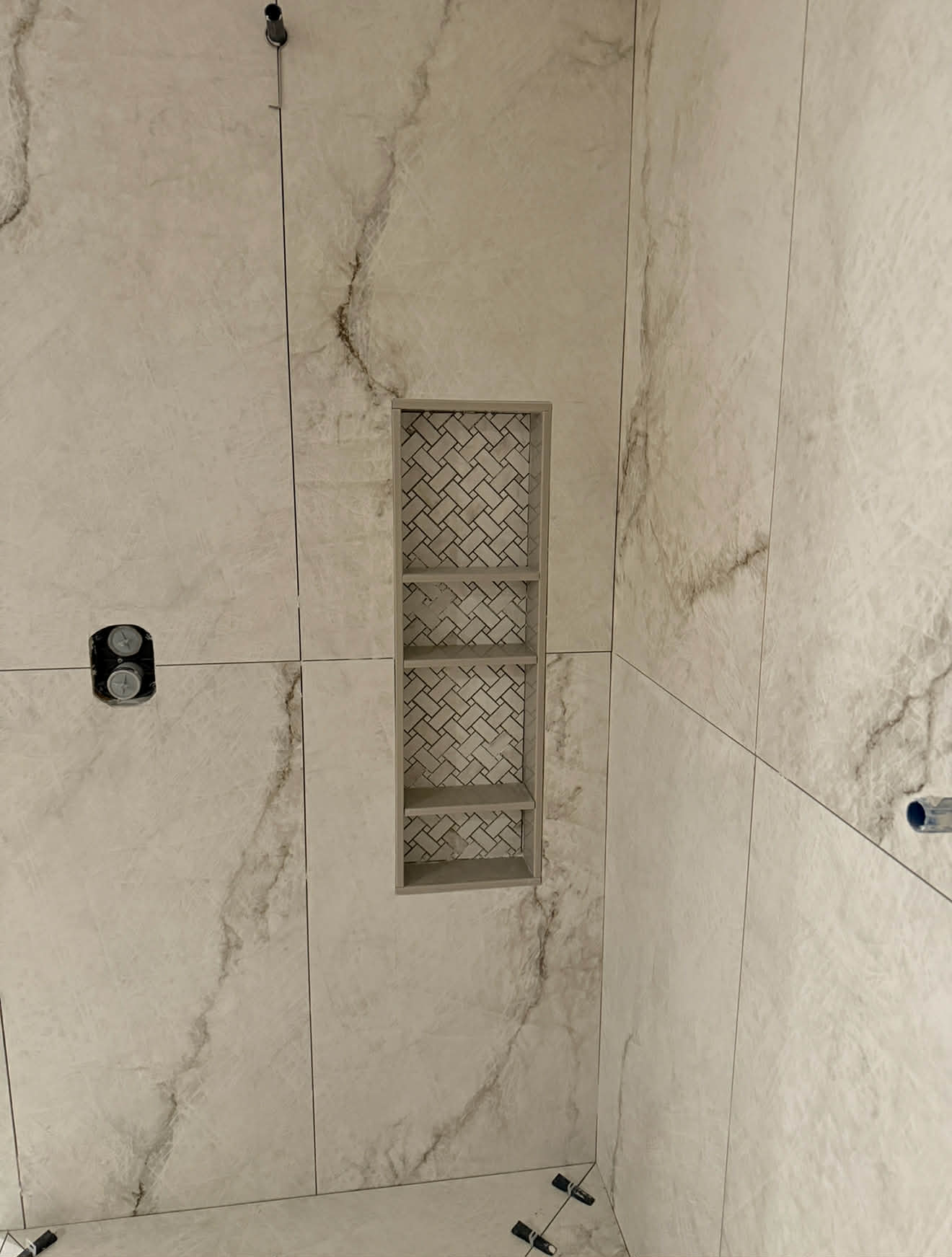 Marble shower niche with herringbone insert