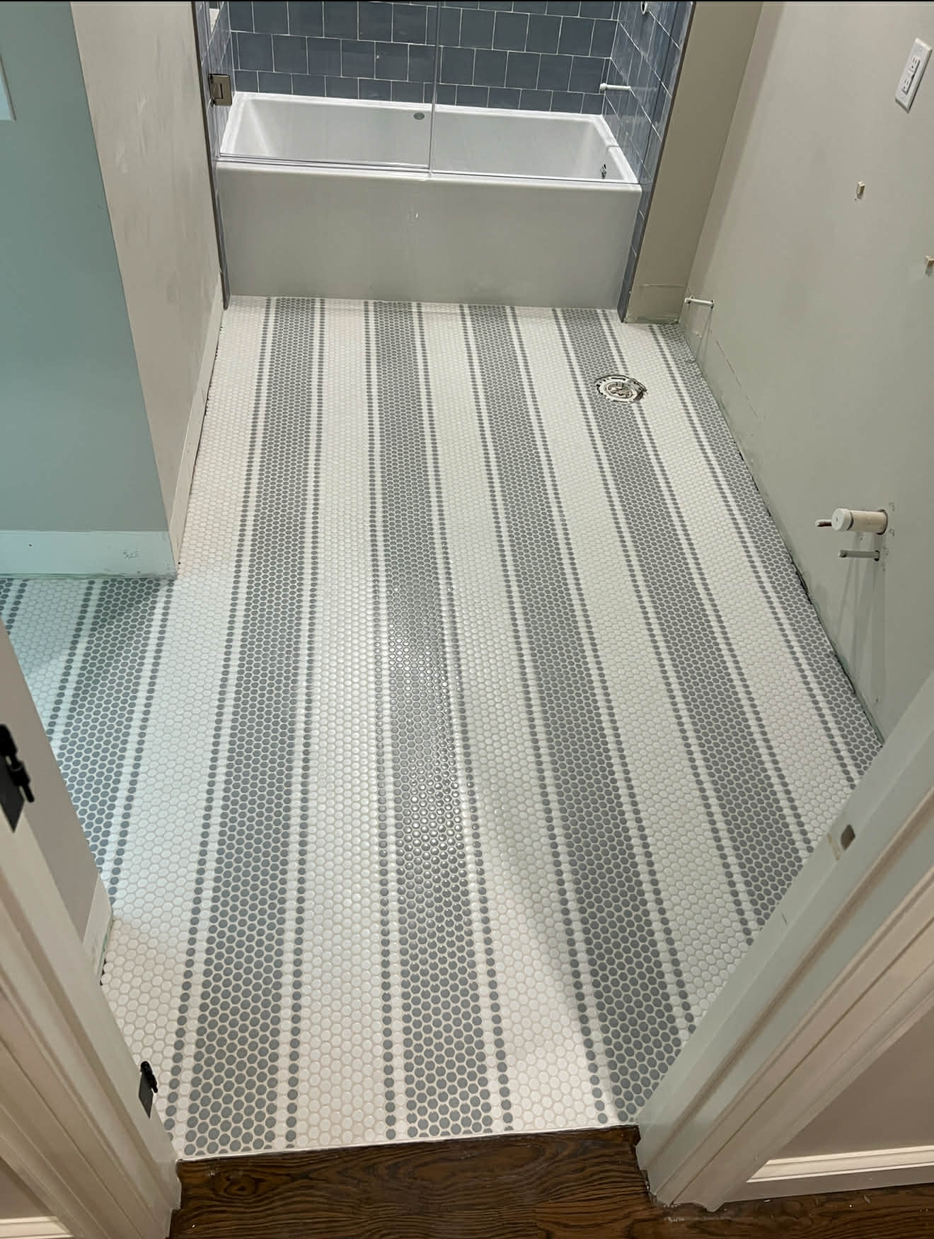Penny tile floor, bathtub with blue subway tile