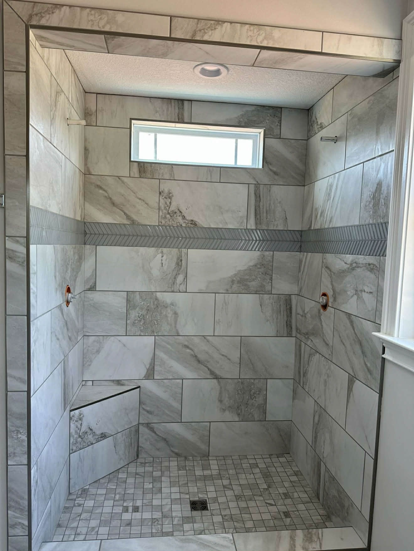 Marble tile shower with decorative border strip