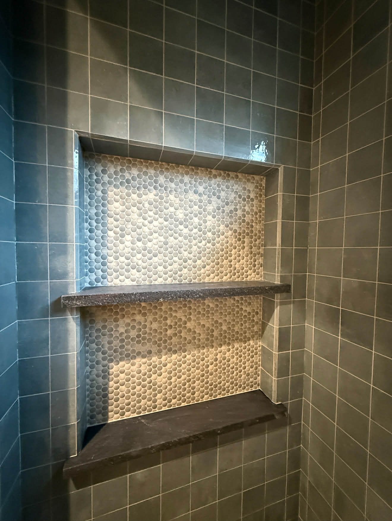 Dark grey tile shower with niche shelves