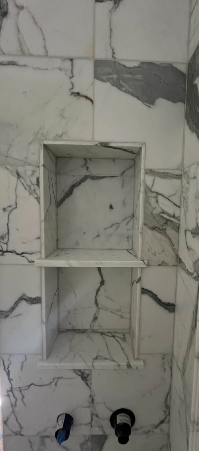 White marble shower niche with shelf