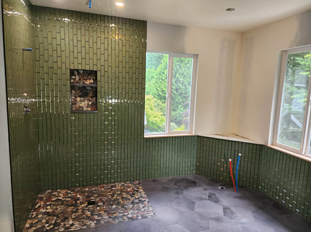Green fluted tile shower with pebble floor