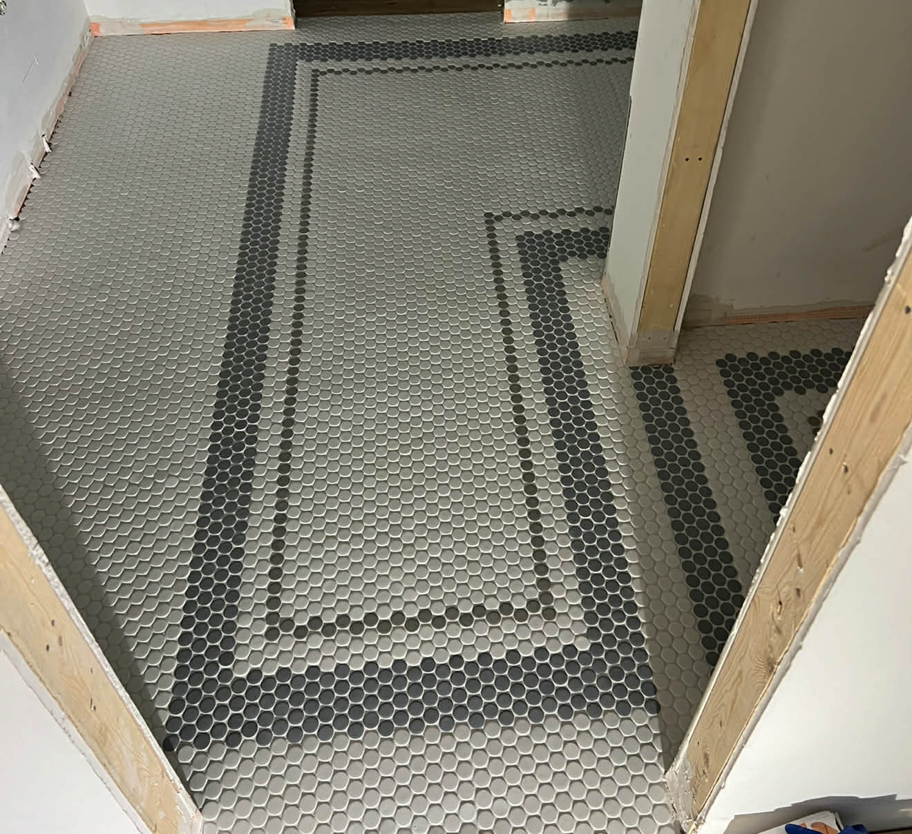 Grey penny hex tile floor under construction