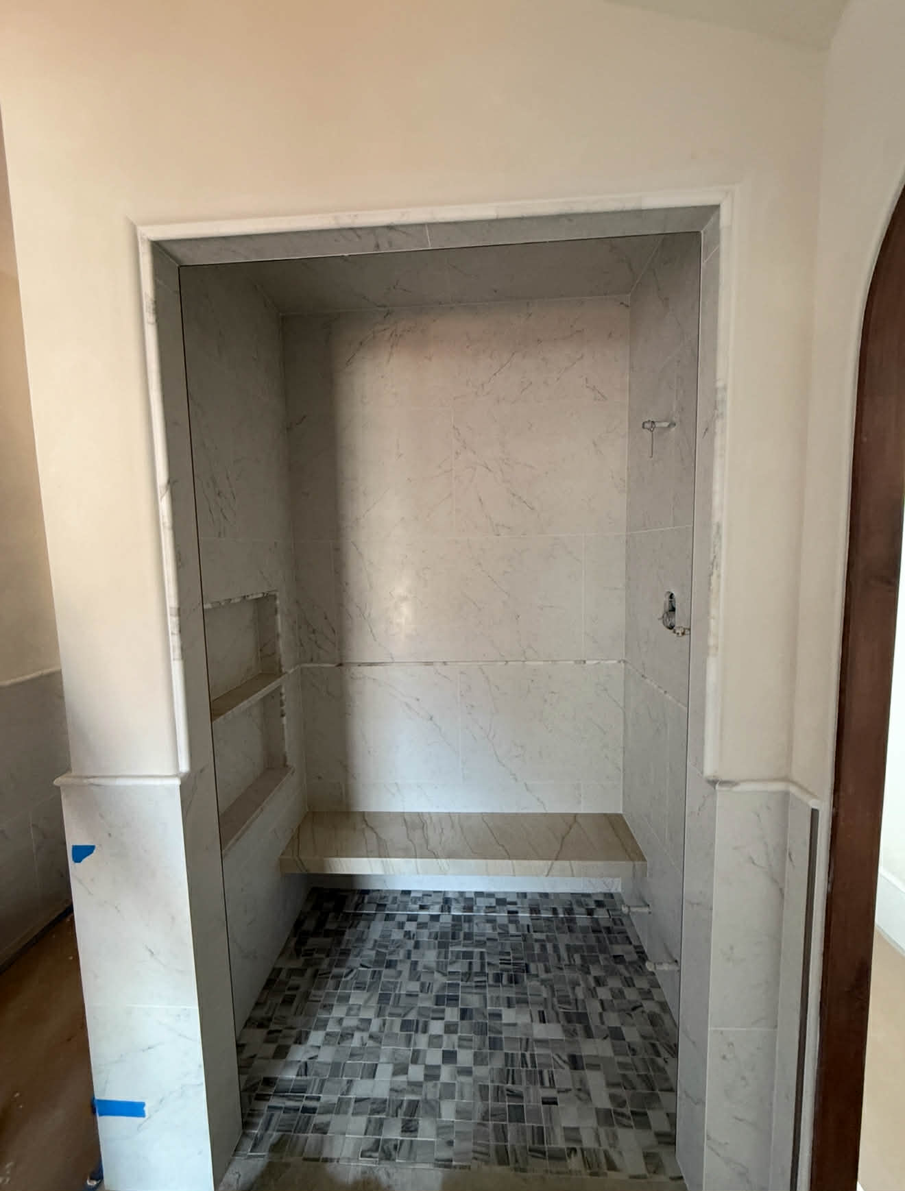 White subway tile shower with mosaic art panel — birds and flowers