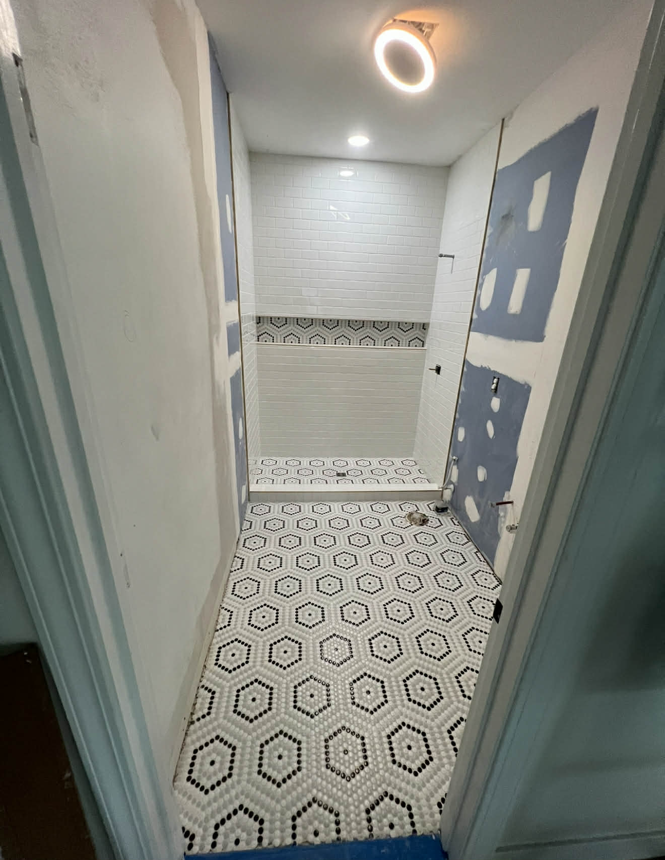 Dark blue-grey walk-in shower with penny tile floor