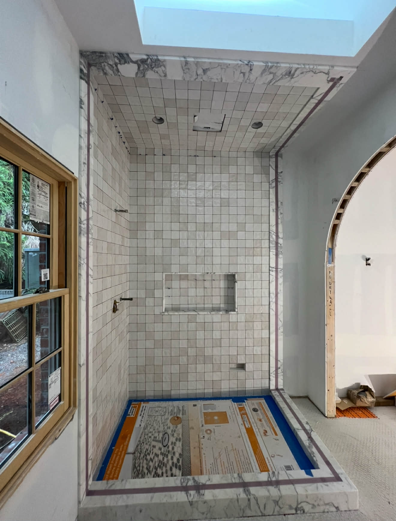 Marble shower with penny mosaic floor