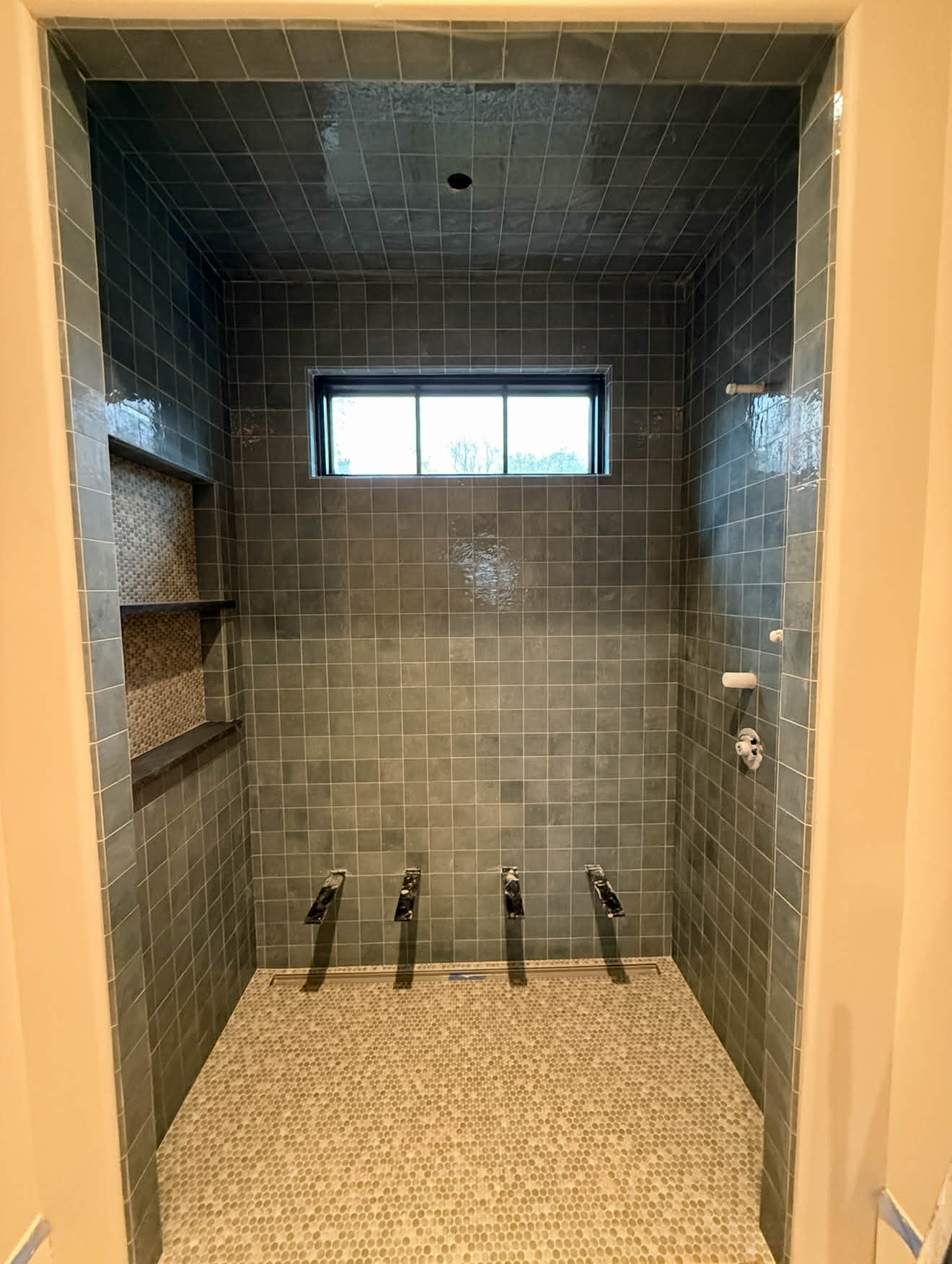 White subway tile shower with black border and hex floor