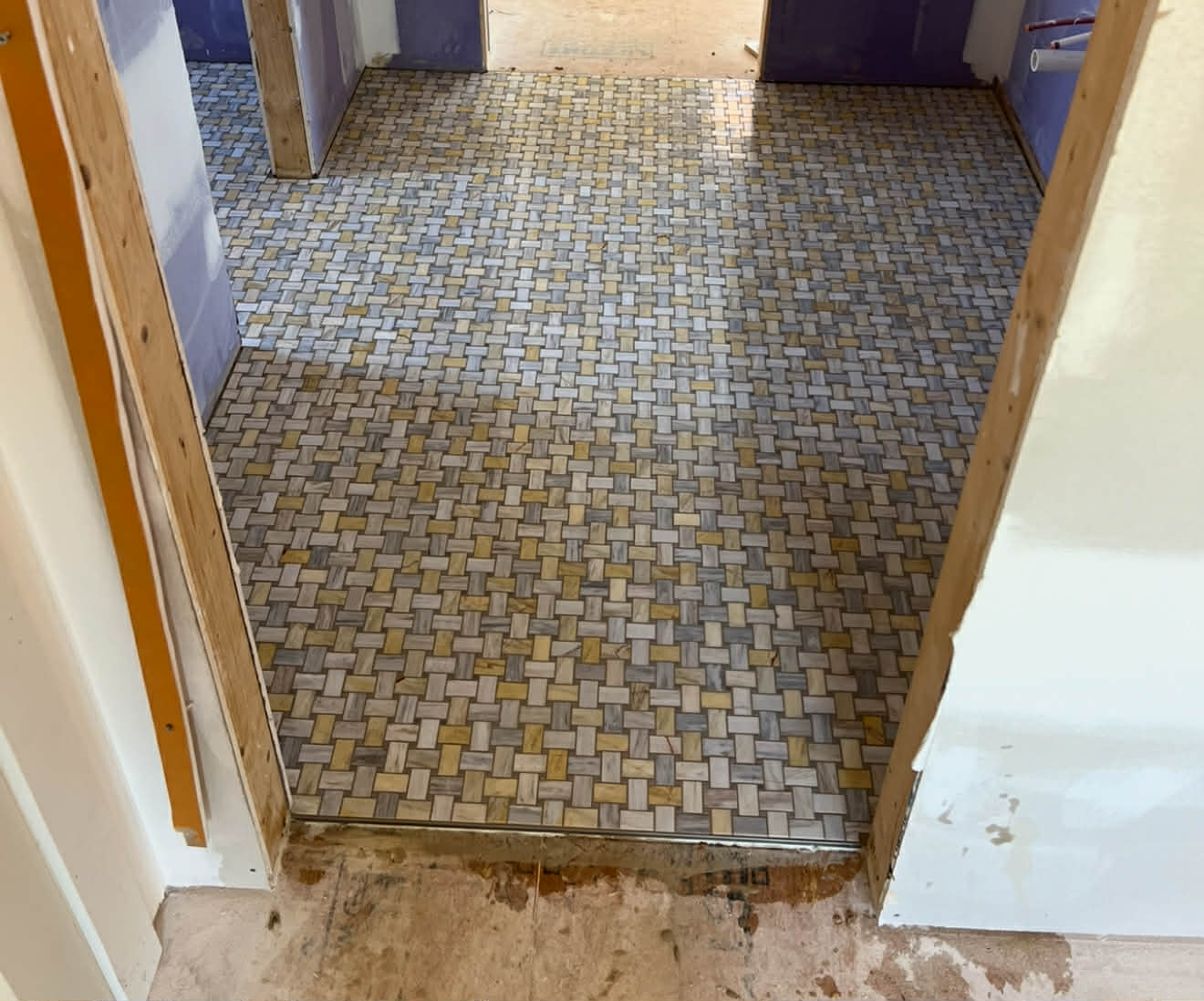 Dramatic calacatta marble shower with ornate mosaic niche