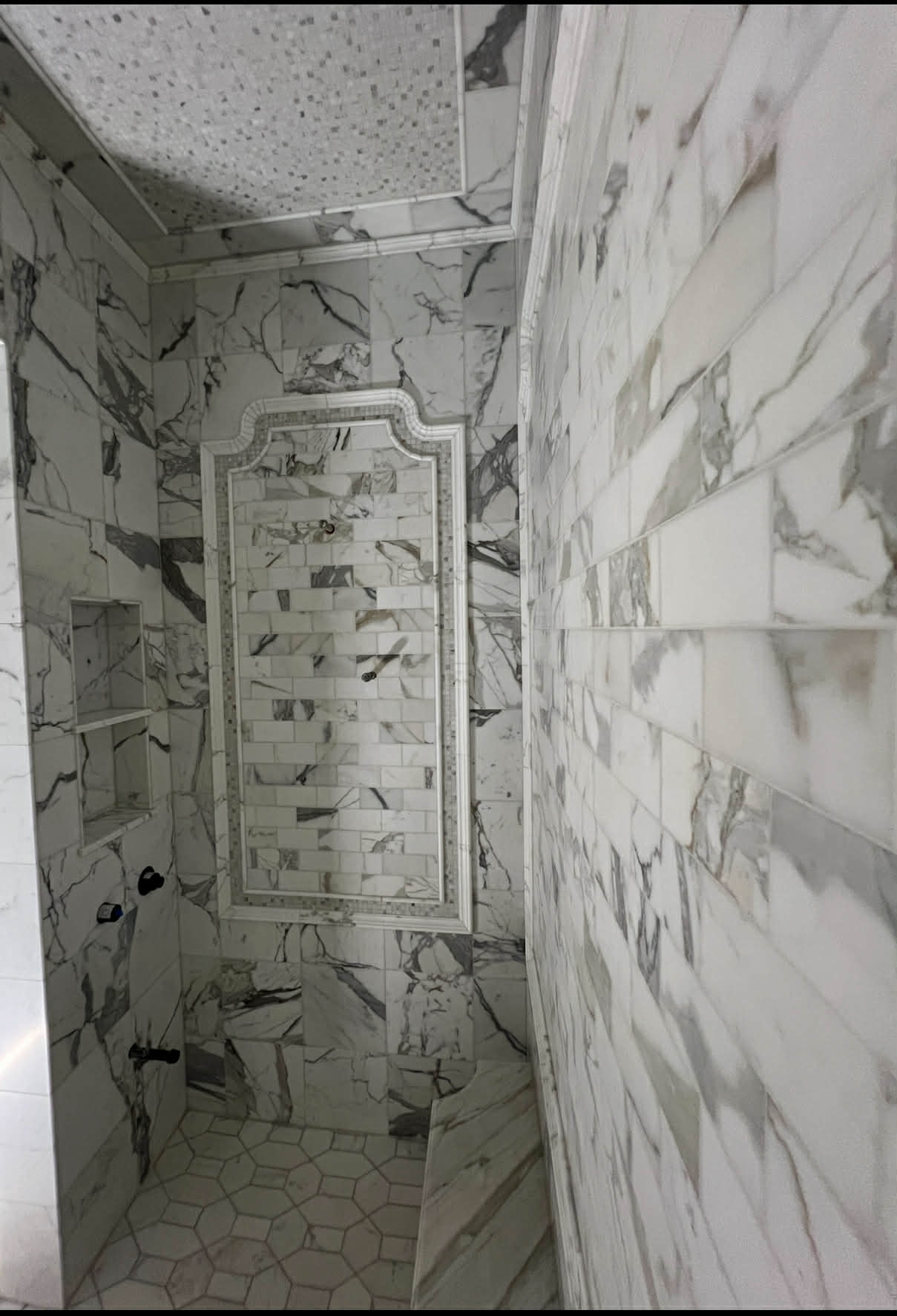 Calacatta marble shower with golden mosaic accent niche